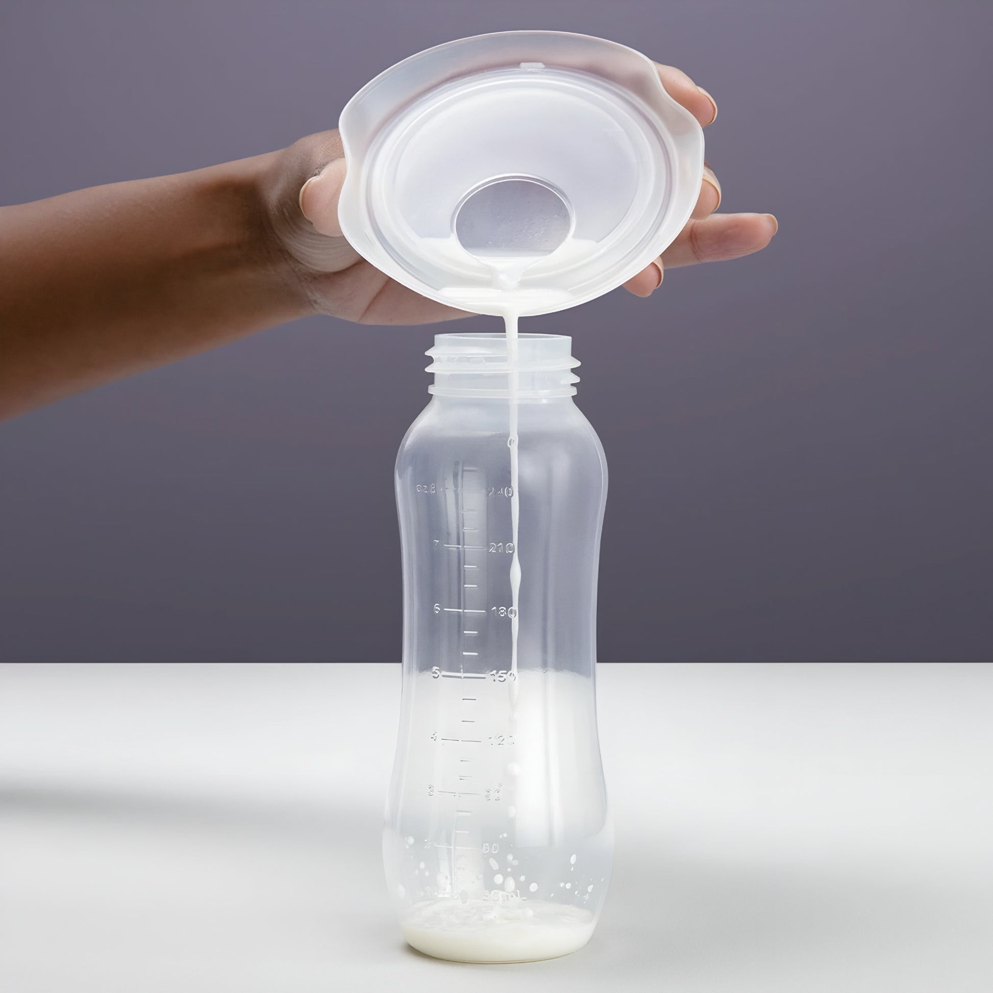 Milk being poured into a secure Elvie milk collection cup.